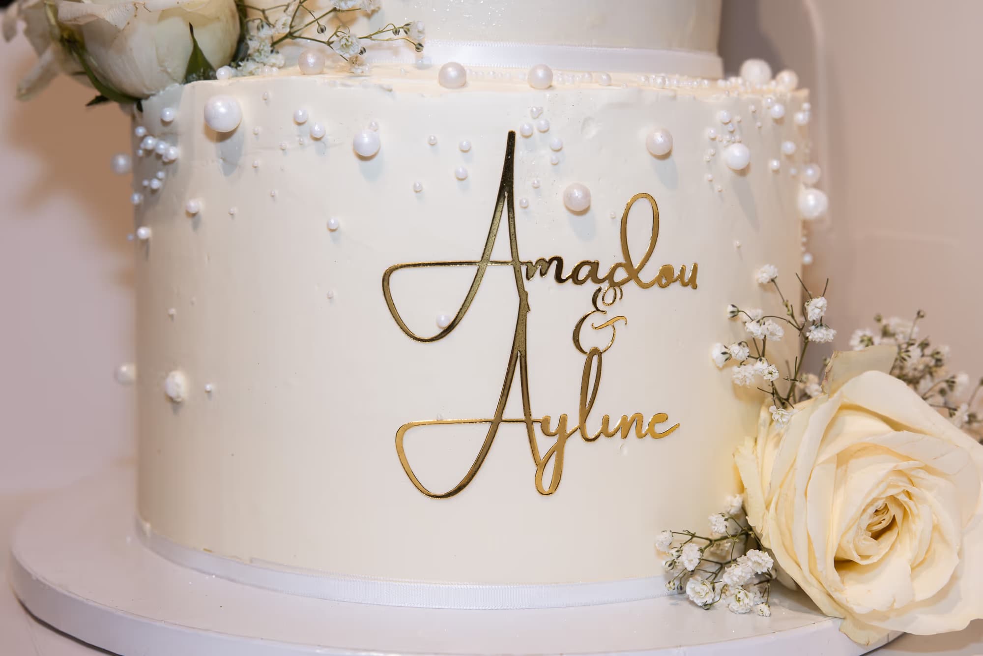 Mariage — les prénoms des mariés en lettres dorées sur le wedding cake