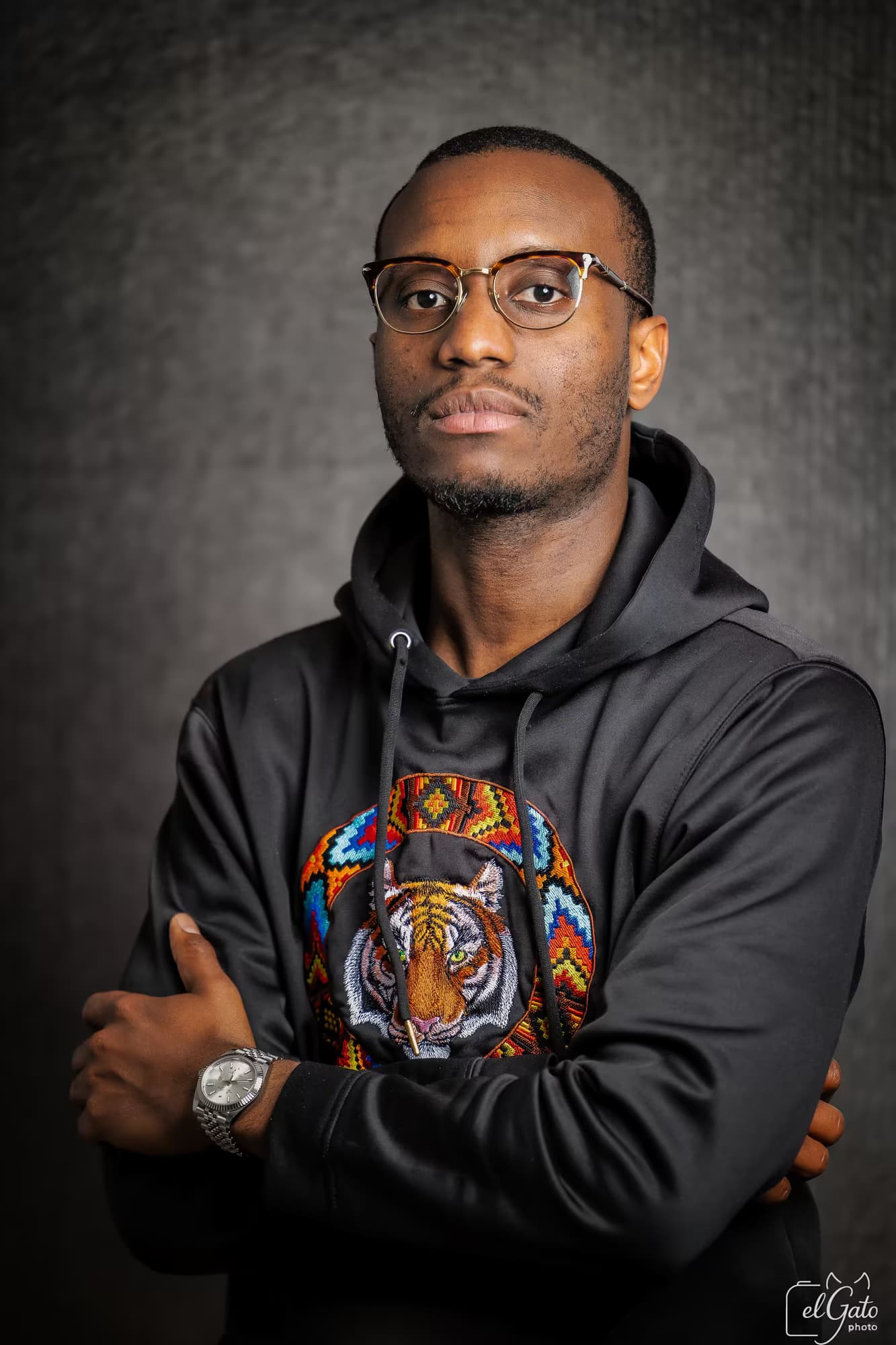 Portrait studio — homme en sweat brodé, bras croisés